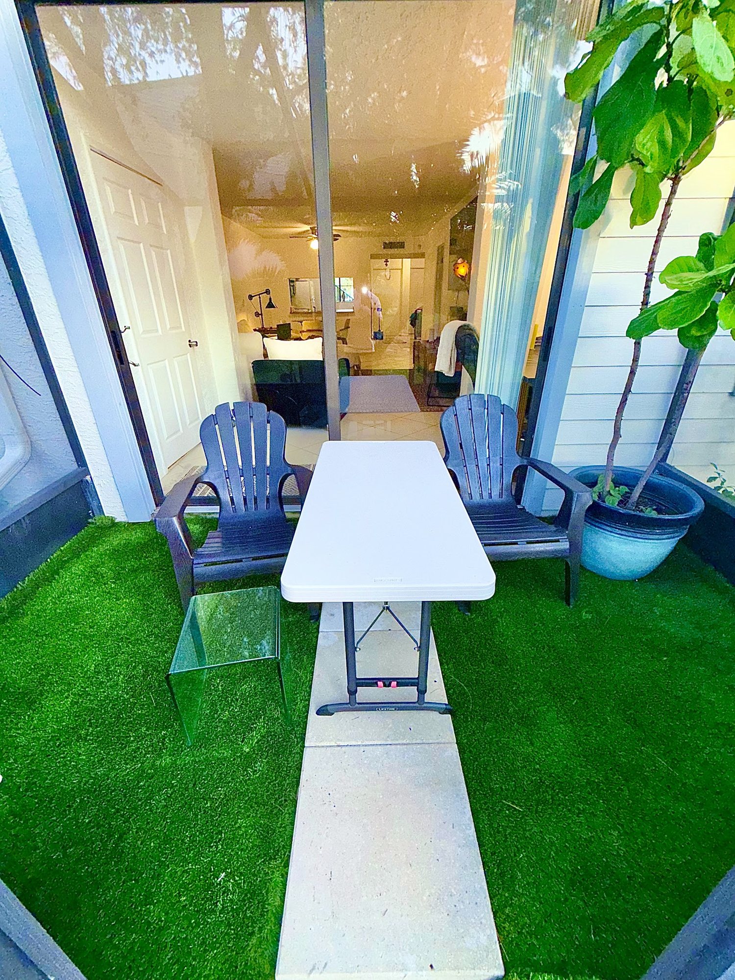 Private screened lanai with turf flooring and Adirondack chairs